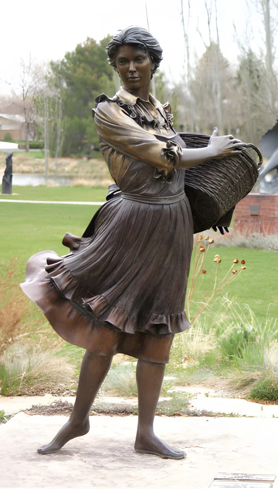 Бронзова скульптура жінки з кошиком